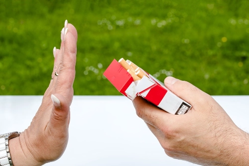 main qui dit stop à une proposition de cigarette. Redevenir non fumeur c'est possible grâce l'hypnose, l'EMDR et la PNL, proche de Cahors